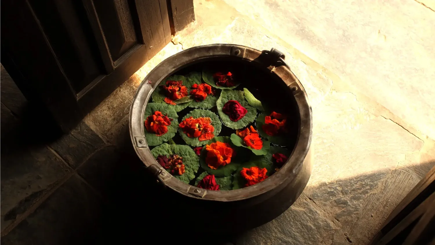 A traditional newari bucket filled with water and flowers